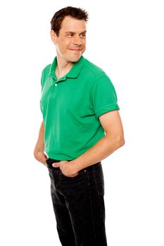 Handsome young man with hands in pocket looking away, turning head back