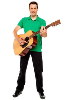 Young caucasian guitarist playing tracks isolated over white background