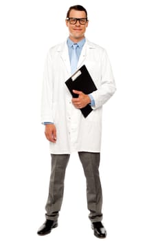 Full length shot of male doctor posing with clipboard over white