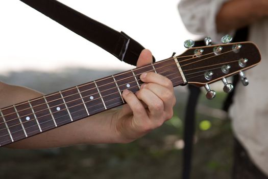 Fingering the guitar strings.