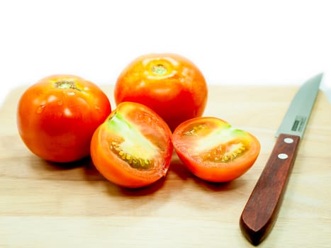 Tomato and knife on cutting board isolated on a white background