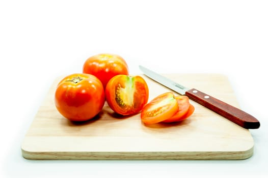 Tomato and knife on cutting board isolated on a white background