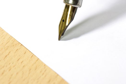 A sheet of white paper and fountain pen with gold nib at the work desk