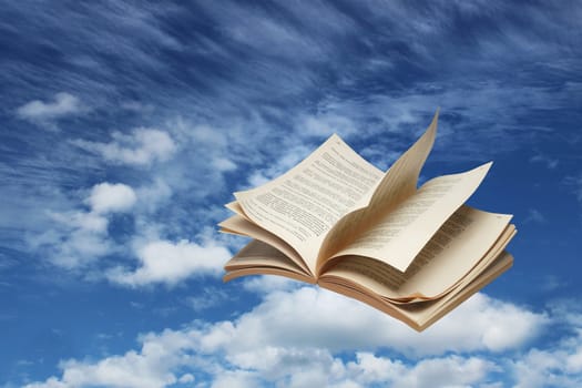 Open book flying on blue sky background fantasy