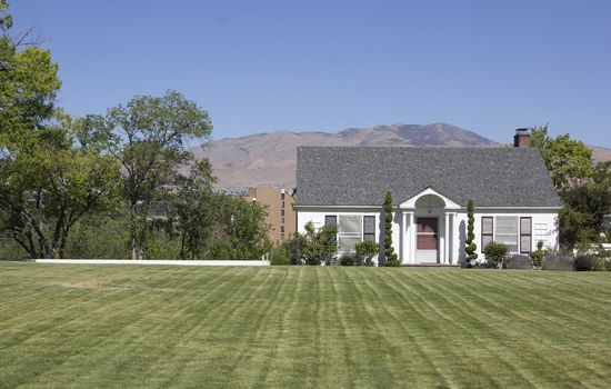 a small country home with perfect green grass.