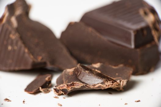 Macro shot of dark chocolate pieces on white.