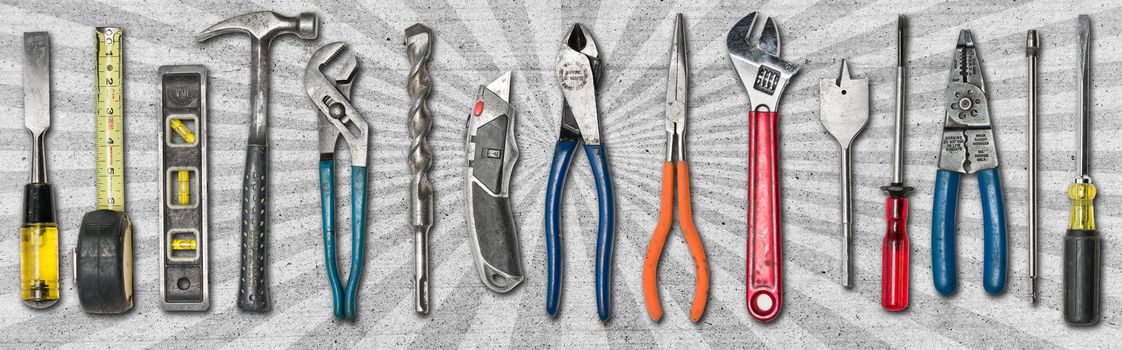 Various used tools on concrete background with star burst