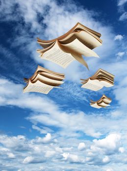 Four open books flying above, blue sky background fantasy