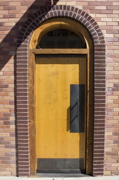 A brick door with an arch in a brick building.