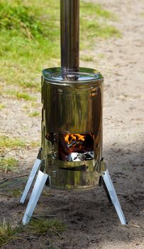 Modular wood stove for the tourist with an open door where the fire is visible