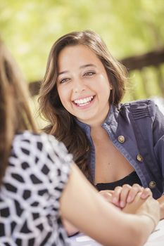 Attractive Girlfriends Laughing Sitting Outdoors.