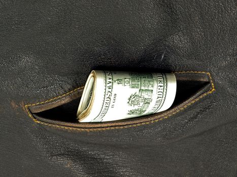Pack of dollars in a pocket of a leather jacket.