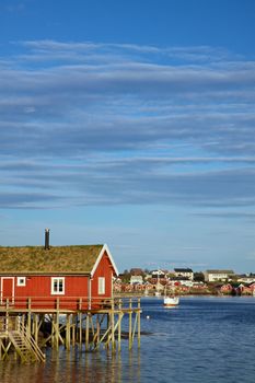 Red fishing rorbu hut by the fjord in town of Reine on Lofoten islands