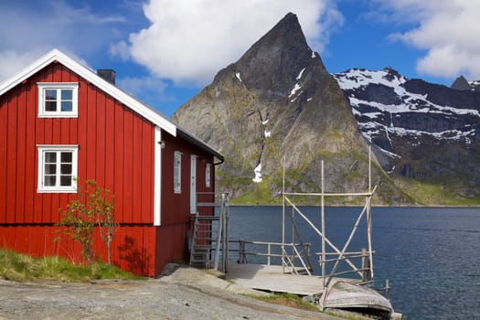 Typical red rorbu fishing hut by the fjord on Lofoten islands in Norway