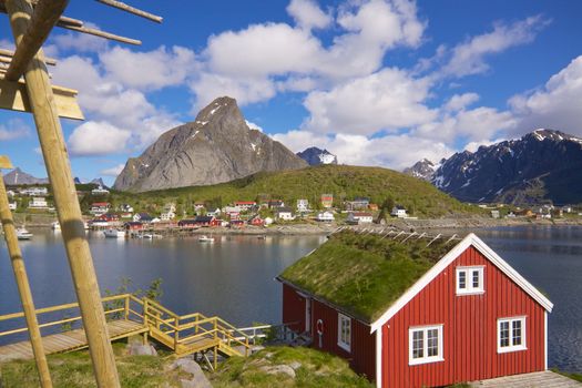 Typical red rorbu hut with sod roof in town of Reine on Lofoten islands in Norway