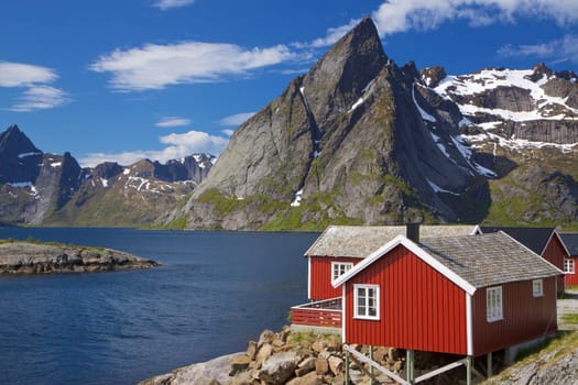 Picturesque red fishing hut on the coast of fjord on Lofoten islands in Norway