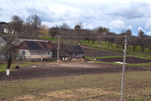 Ukrainian village with old wooden houses and fields