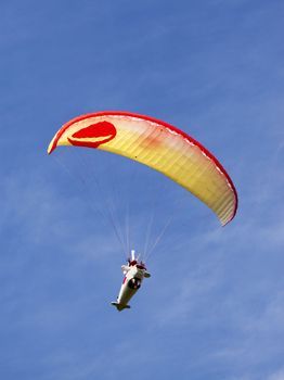 A para glider in an airplane costume floats overhead.