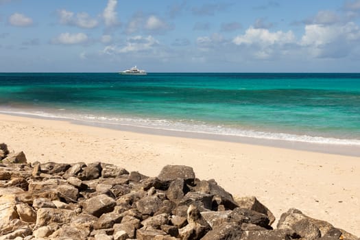 Tropical Caribbean Beach Seascape with Motor Yacht and Blue Sky on Beautiful Sunny Day
