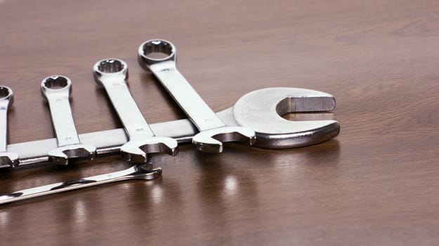 Some steel wrenches of different sizes on a desktop