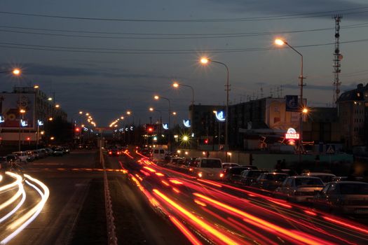 Night street with traces from light of headlights shined with street lanterns