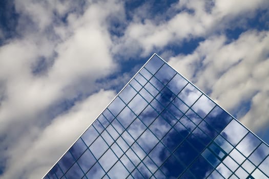 windows of skyscraper with reflections on a background cloudy sky