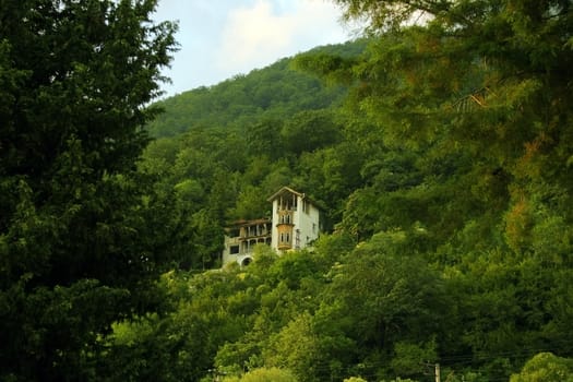 Standing alone at mountain top an old small house in a wood environment