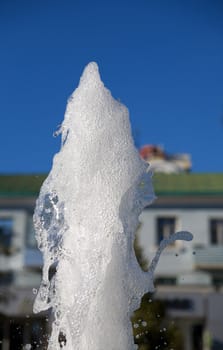 Fountain of pure brilliant water against a blue clear sky