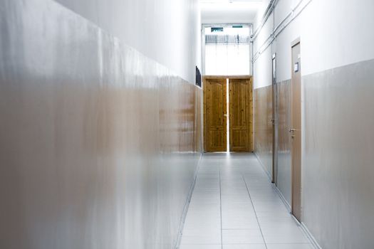 Narrow corridor of office building with wooden doors
