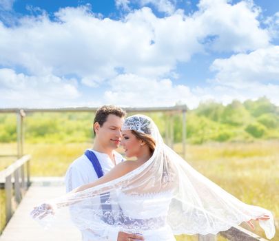 Couple in wedding day outdoor with wind on veil