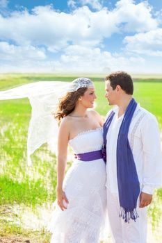 Couple in wedding day outdoor with wind on veil