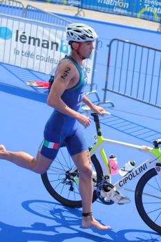 GENEVA, SWITZERLAND - JULY 22 : unidentified athlet running next ot its bike at transition space at the International Geneva Triathlon, on July 22, 2012 in Geneva, Switzerland.