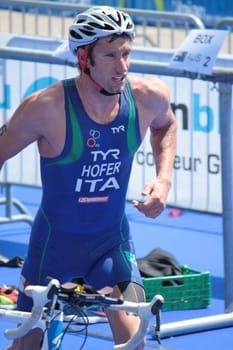 GENEVA, SWITZERLAND - JULY 22 : unidentified athlet running next ot its bike at transition space at the International Geneva Triathlon, on July 22, 2012 in Geneva, Switzerland.