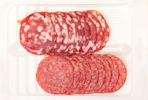 Slices Salami in container on a white background