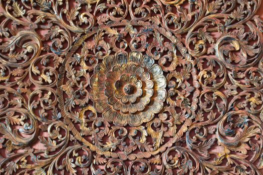 Thai flower carved on wooden door temple in natural color