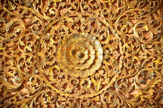 Thai flower carved on wooden door temple in golden color