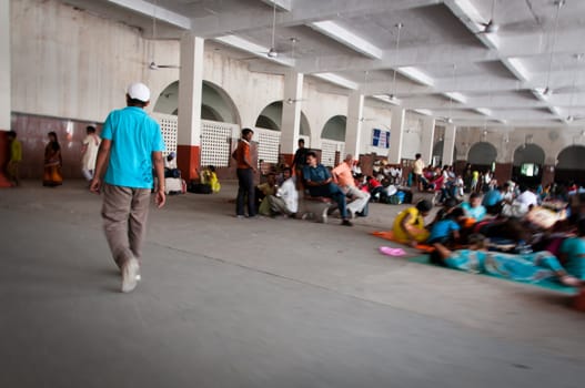 Amritsar, India - August 26, 2011: Passengers of the great Indian railway transport system take a rest on the station