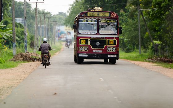 Habarana, Sri Lanka - December 6, 2011: Regular public bus from Colombo to Sri Pura and motorbikes. Buses are the most popular public transport type in Sri Lanka.