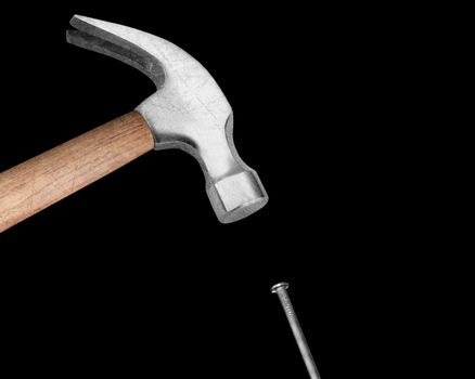 Hammer hitting a nail on black background.