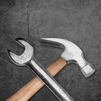 spanner and hammer on Scratched metal background.