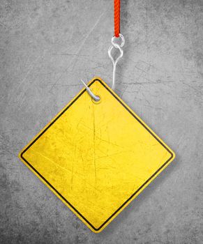 Alert yellow sign hanging by fishhook, conceptual image for under construction and coming soon
