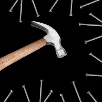 Hammer hitting a nails on black background.