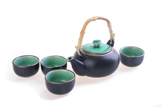 Chinese tea set with cups and tea pot on background.