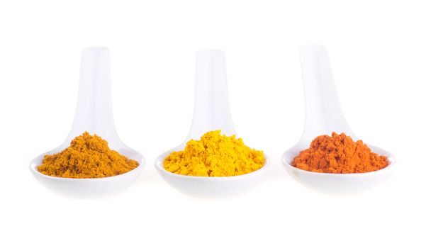 spices in the spoons on a white background