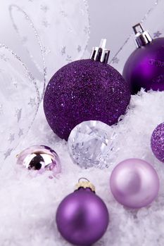 beautiful christmas decoration in purple and silver on white snow sparkle