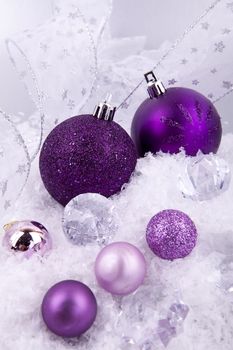 beautiful christmas decoration in purple and silver on white snow sparkle