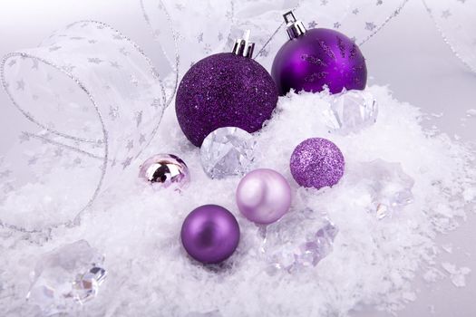 beautiful christmas decoration in purple and silver on white snow sparkle