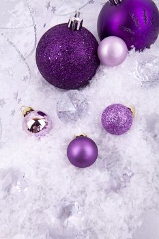 beautiful christmas decoration in purple and silver on white snow sparkle