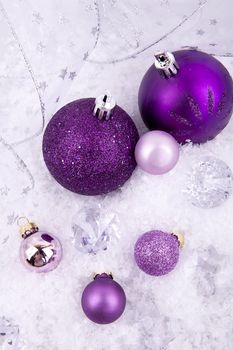 beautiful christmas decoration in purple and silver on white snow sparkle