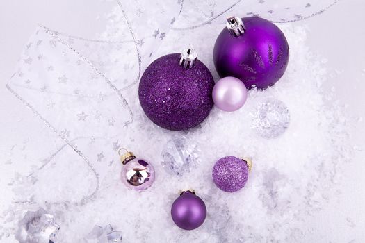 beautiful christmas decoration in purple and silver on white snow sparkle